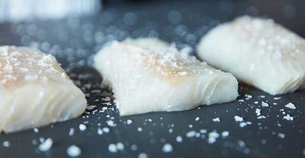 شرائح فيليه من سمك الفحم على لوح التقطيع